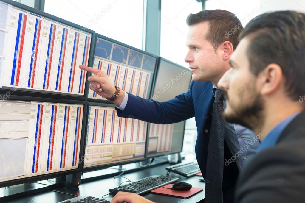 Stock traders looking at computer screens.