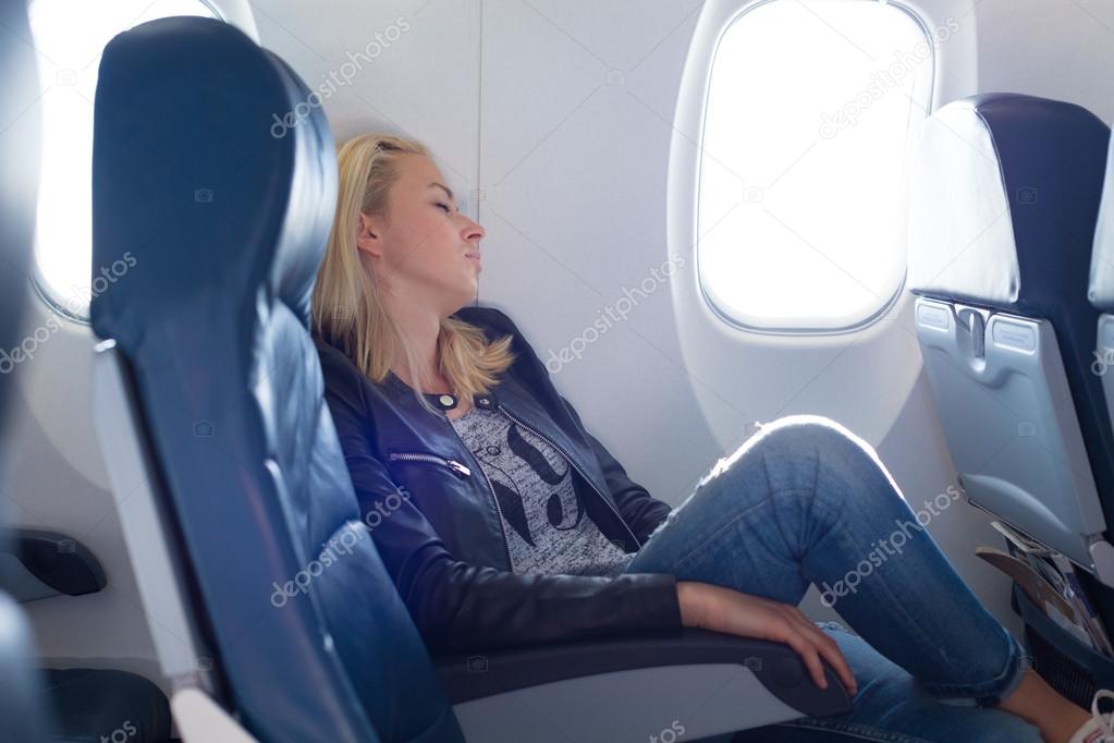 Lady traveling napping on a plain.