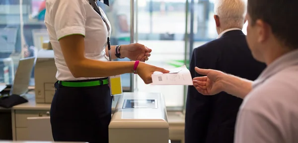 Handing over air ticket at airline check in counter — Stock Photo, Image