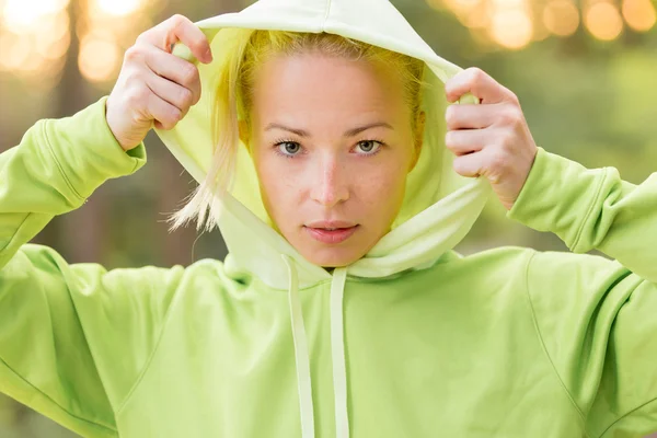 Vertrouwen sportieve vrouw dragen van modieuze groene hoodie. — Stockfoto