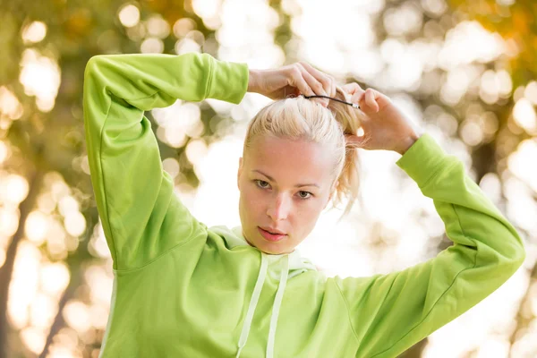 Vertrouwen sportieve vrouw dragen van modieuze groene hoodie. — Stockfoto