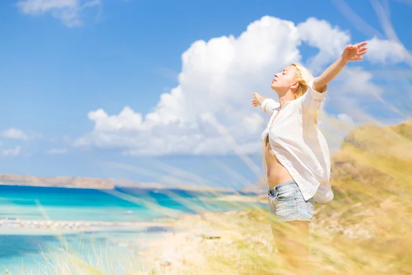 Kostenlose glückliche Frau genießt Sonne im Urlaub. — Stockfoto