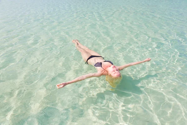 Senhora caucasiana flutuando no mar azul-turquesa . — Fotografia de Stock