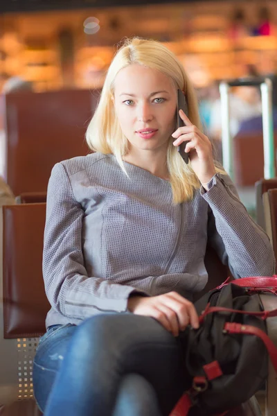 Viajante feminino usando telefone celular enquanto espera . — Fotografia de Stock