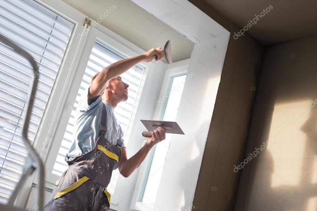 Plasterer renovating indoor walls and ceilings.