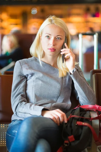 Female traveler using cell phone while waiting. — Stock Photo, Image