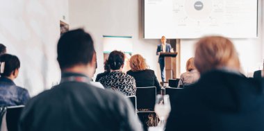 Sözcü, iş konferansında konferans salonunda konuşma yapacak. Konferans salonundaki tanınmayan insanların arka görüntüsü. İş ve girişimcilik kavramı