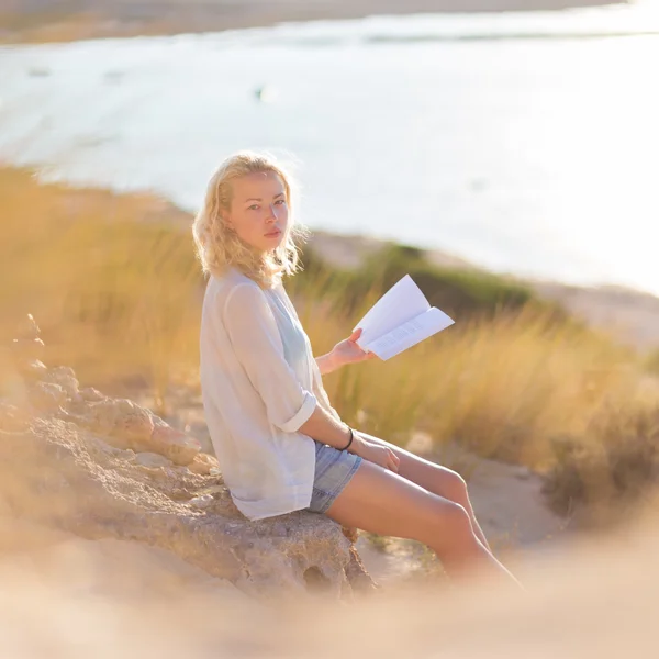 Žena se těší čtení na krásné písečné pláži. — Stock fotografie