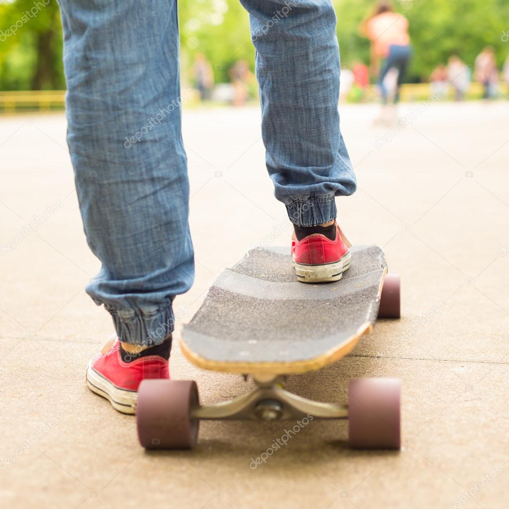 Teenage girl practicing riding long board.