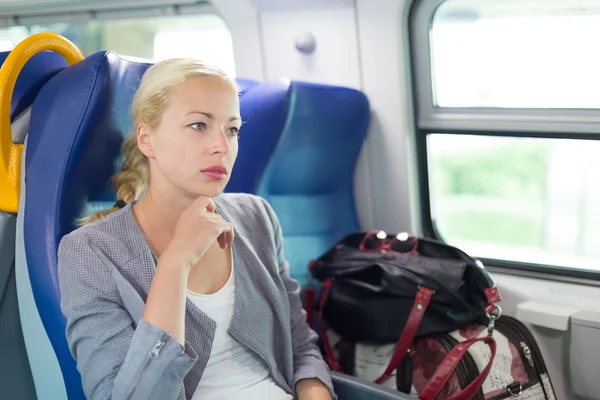 Blonde Geschäftsfrau mit dem Zug unterwegs. — Stockfoto