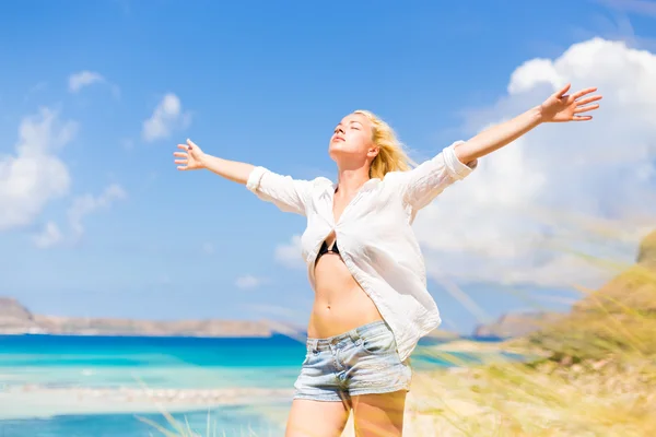 Kostenlose glückliche Frau genießt Sonne im Urlaub. — Stockfoto