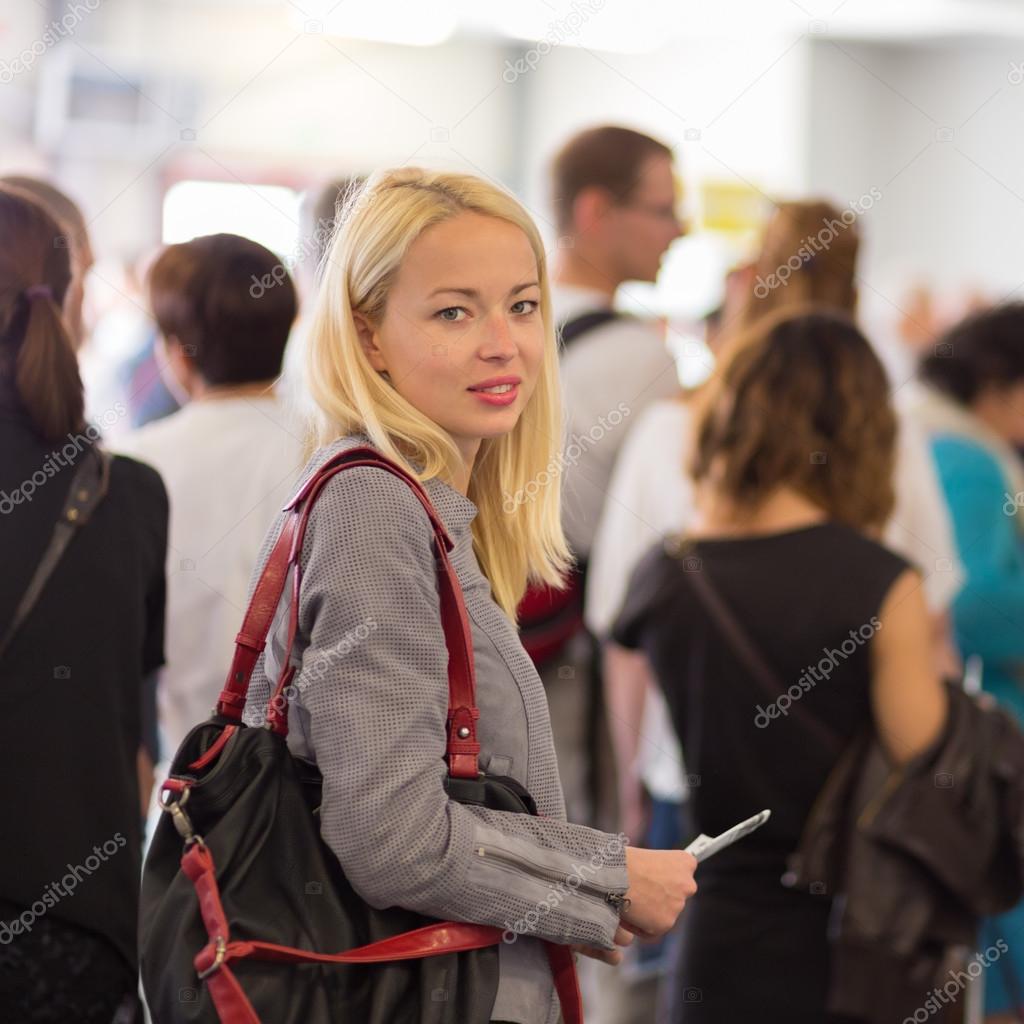 Young blond caucsian woman waiting in line.