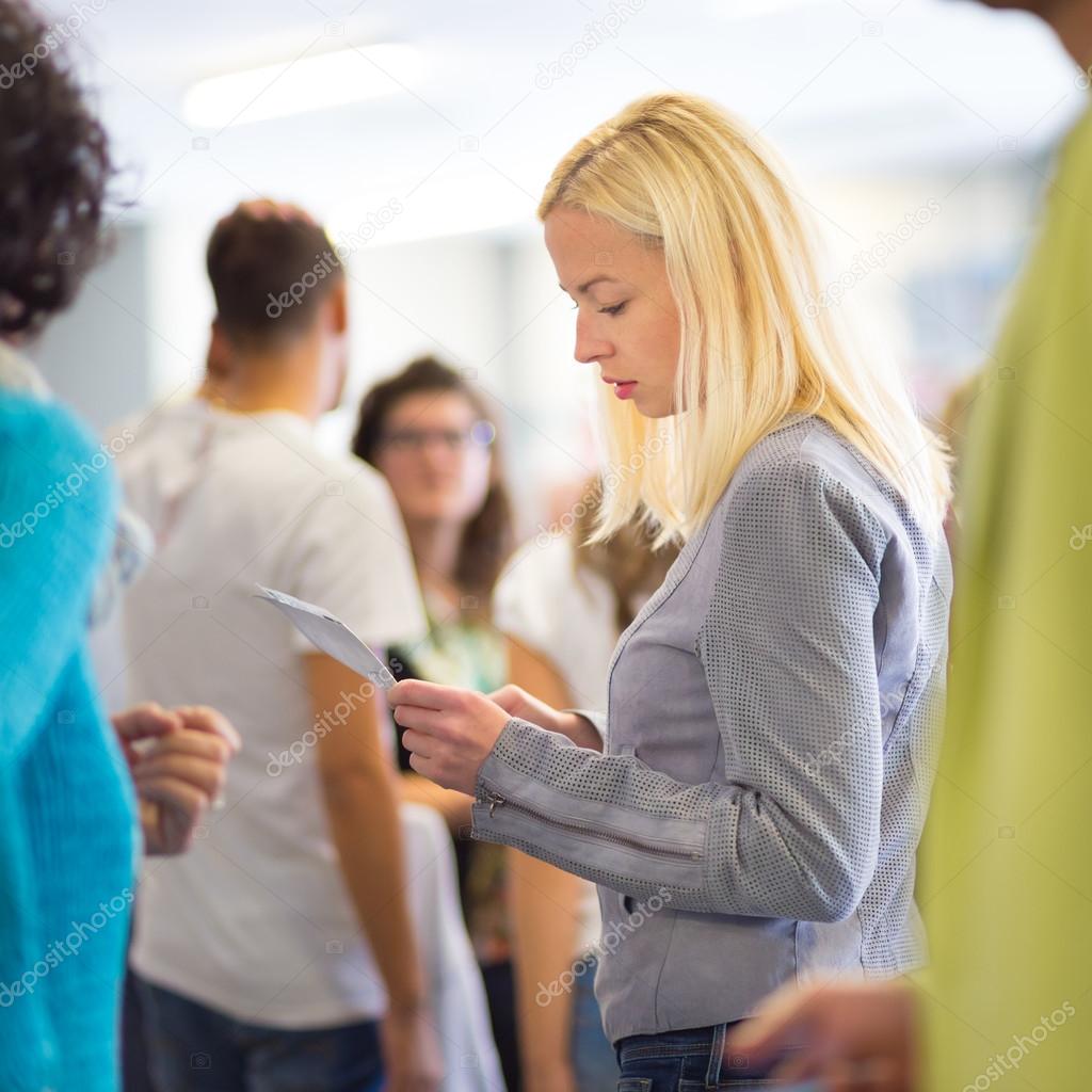 Young blond caucsian woman waiting in line.