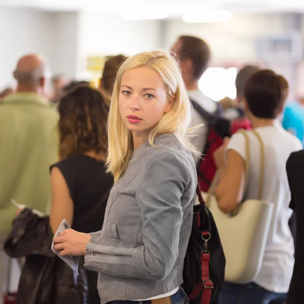 Junge blonde Kaukasierin wartet in der Schlange. — Stockfoto