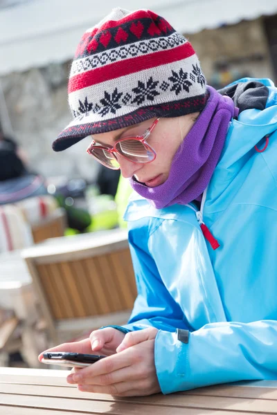 Vrouw in skigebied gebruikend smartphone. — Stockfoto