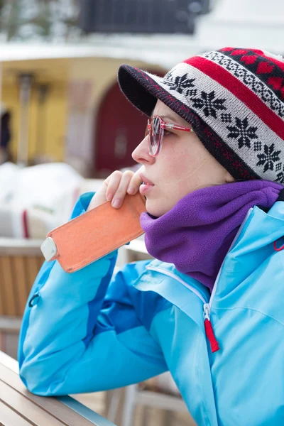 Mulher em estância de esqui usando smartphone . — Fotografia de Stock