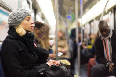 Metroda insanlarla dolu uyuklayan kadın.