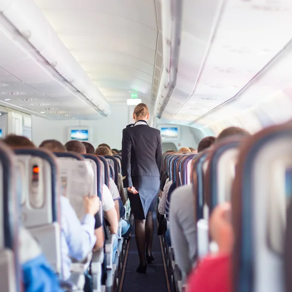 Hôtesse et passagers dans un avion commercial . — Photo
