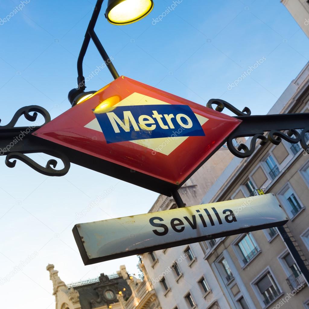 Detail of Vintage Sevilla Metro Station Sign in Madrid Spain, illuminated in dusk.