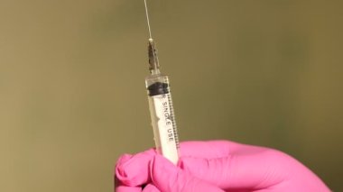 Macro, şırınga iğnesini yavaş çekimde kapat. Aşı enjeksiyonu. Doktor İğne Kullanıyor. Sağlık ve tıbbi kavramlar. Kızıl Efsane Ejder Kamerası ile çekim yap.