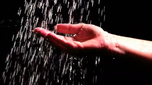 黒い背景に手の動きの遅い映像に水が注ぐ レッド エピック ドラゴンのカメラで撃つ — ストック動画
