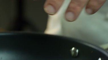 Şef kızartma tavasına doğranmış soğan ekler