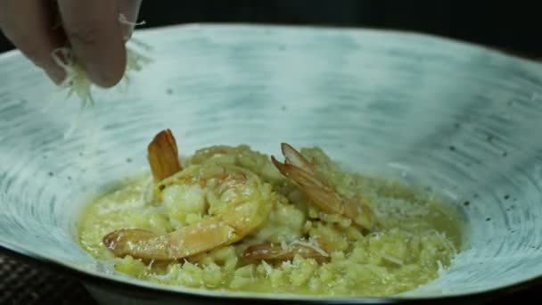 Chef voegt geraspte kaas toe aan gekookte risotto — Stockvideo