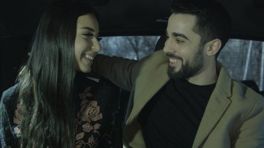 Genç bir adam ve genç bir kız arabada oturuyorlar. Birbirleriyle konuşup hayranlık duyuyorlar. Arabada birbirine aşık bir çift var. Fotoğraf, yine de görüntü..
