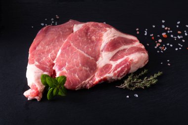 Yiyecek konsepti. Kasaplığın ham parçaları. Siyah tahta üzerinde domuz eti dilimi.