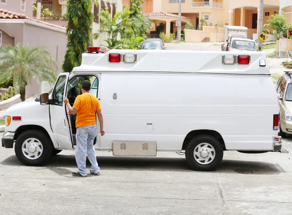 Ambulance blanche avec le chauffeur sortant pour aider le paramedi — Photo