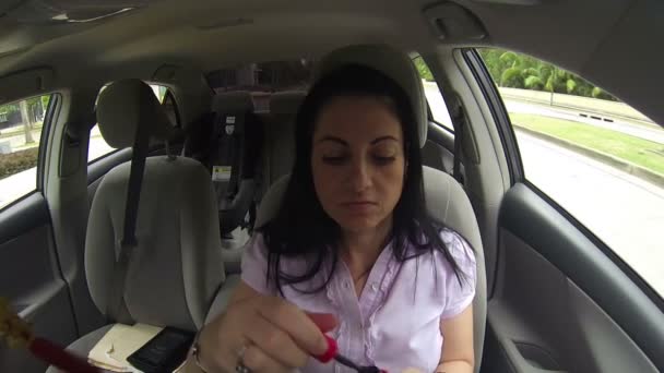 Jeune femme appliquant le maquillage dans la voiture — Video