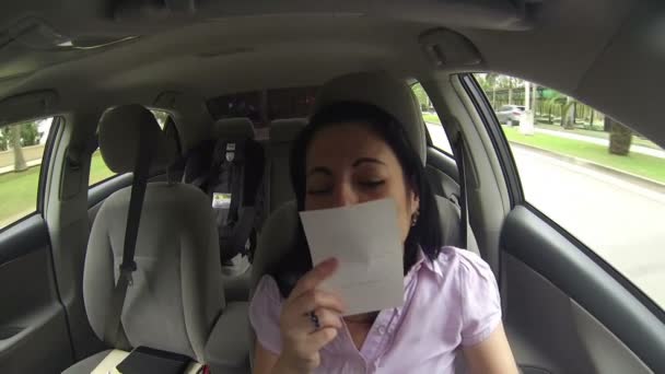 Sad woman driving a car missing someone she love in a photo she has in her hands — Stock Video