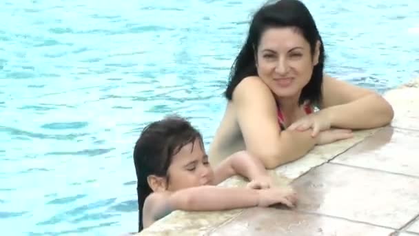 Happy mother and daughter girl at swimming pool in summer vacation — Stock Video