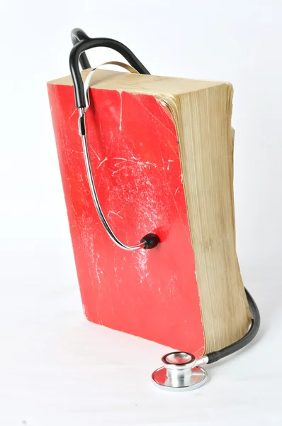 Estetoscópio no livro velho vermelho — Fotografia de Stock