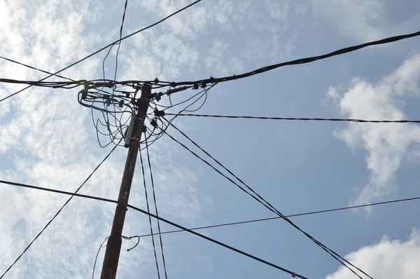 Pólos de eletricidade contra o céu azul — Fotografia de Stock