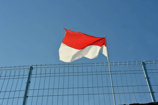 Indonesiens Röda Och Vita Flaggor Fladdrar Järnstång Bakom Ett Stängsel — Stockfoto