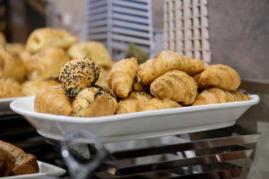 Lezzetli kruvasanlar sergileniyor. Taze pişmiş hamur işleri kahvaltı, brunch ya da yemek organizasyonları için mükemmeldir..