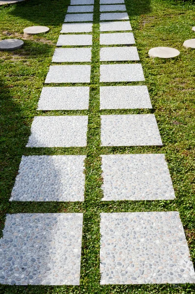 A curvaceous foothpath made of concrete blocks across the grass — Stock Photo, Image