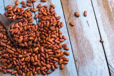 Mavi ahşap masa üstünde tahta kaşıkla kırmızı fasulye