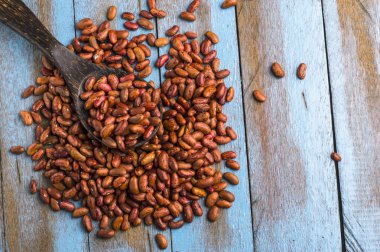 Mavi ahşap masa üstünde tahta kaşıkla kırmızı fasulye