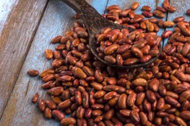 Mavi ahşap masa üstünde tahta kaşıkla kırmızı fasulye