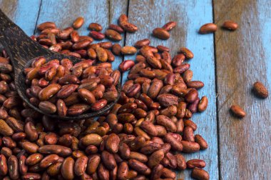 Mavi ahşap masa üstünde tahta kaşıkla kırmızı fasulye