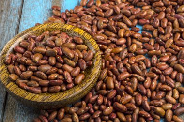 Mavi ahşap masa üstünde tahta kaşıkla kırmızı fasulye