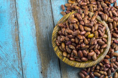 Mavi ahşap masa üstünde tahta kaşıkla kırmızı fasulye