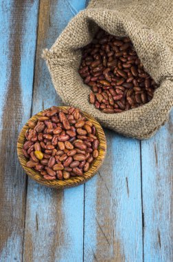 Mavi ahşap masa üstünde tahta kaşıkla kırmızı fasulye