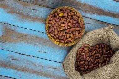 Mavi ahşap masa üstünde tahta kaşıkla kırmızı fasulye