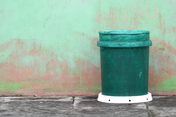 Grüner Plastik-Mülleimer gegen die Wand — Stockfoto