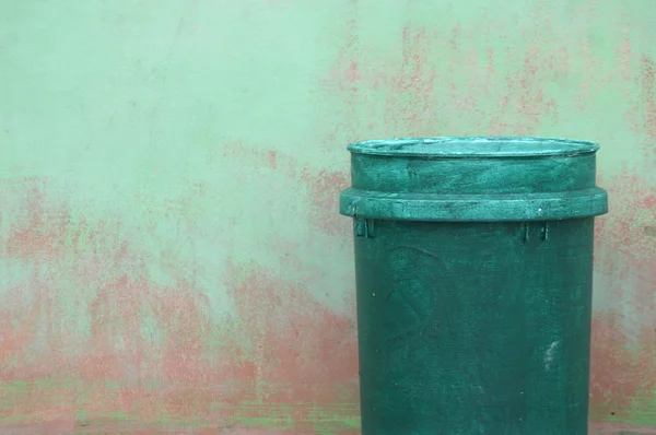 Grüner Plastik-Mülleimer gegen die Wand — Stockfoto