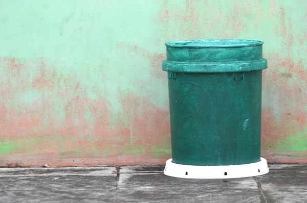 Grüner Plastik-Mülleimer gegen die Wand — Stockfoto