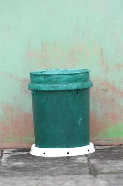 Lata de lixo plactic verde contra a parede — Fotografia de Stock